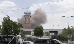 Yemen Conflict with smoke rising after an airstrike at Sanaa International Airport