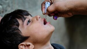 Healthcare worker administering a routine vaccine to a child in Pakistan.