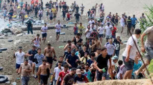 Migrants crossing from Morocco into Spain's Ceuta enclave amid heightened border security.