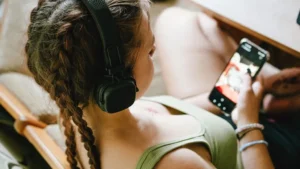 Teenager using YouTube on a smartphone while browsing recommended videos.