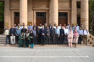 Senior State Bank of Pakistan officials pose with journalists after a briefing on the Prime Minister Housing Loan Scheme.