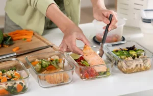 High-protein foods such as eggs, chicken breast, fish, Greek yogurt, beans and pumpkin seeds arranged on a table.