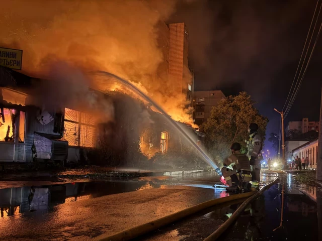 Emergency workers at a damaged building after Russian missile strikes in Kyiv