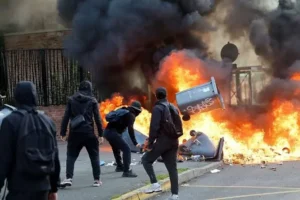 French students protest outside a school as police monitor demonstrations.