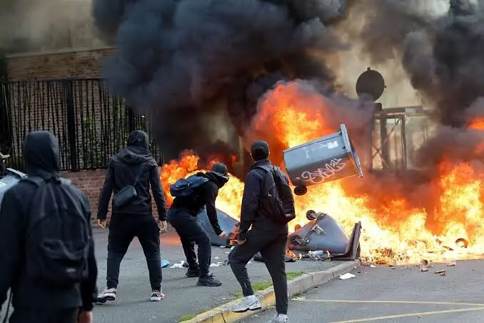French students protest outside a school as police monitor demonstrations.