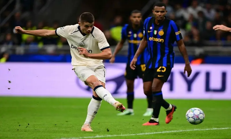 Football players competing during a Champions League match between Club Brugge and Inter Milan.